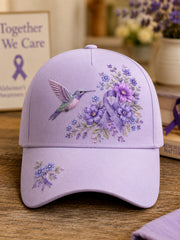 Unisex-Mütze in Lila mit Blumen- und Kolibri‑Muster zur Sensibilisierung für die Alzheimer‑Krankheit