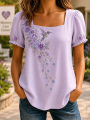 Damen-Shirt in Lila mit Blumen- und Kolibri-Print zur Sensibilisierung für Alzheimer